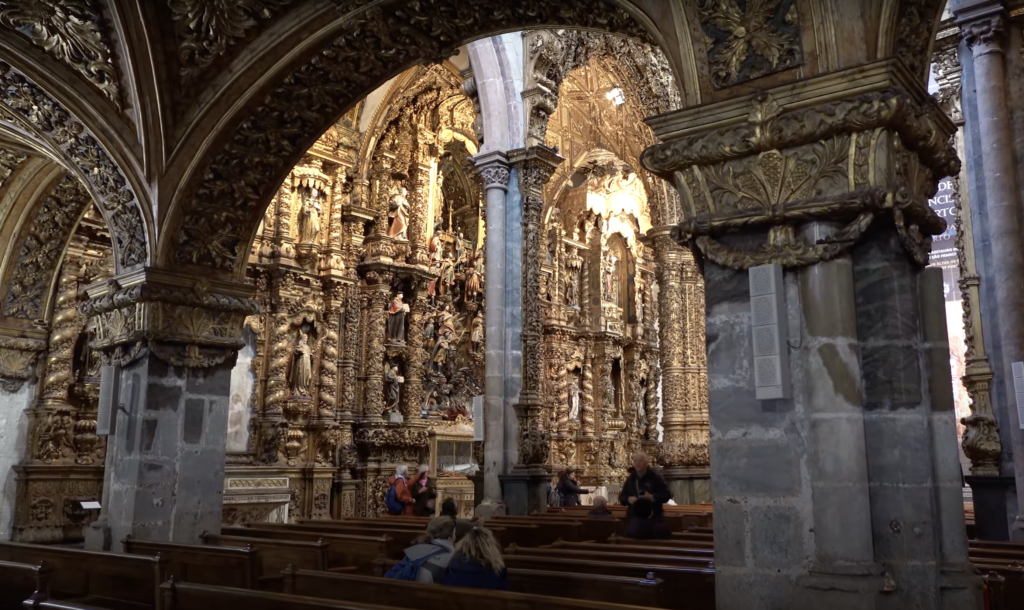 Lavish baroque interior of Igreja de São Francisco in Porto, adorned with gold leaf woodwork and intricate carvings.