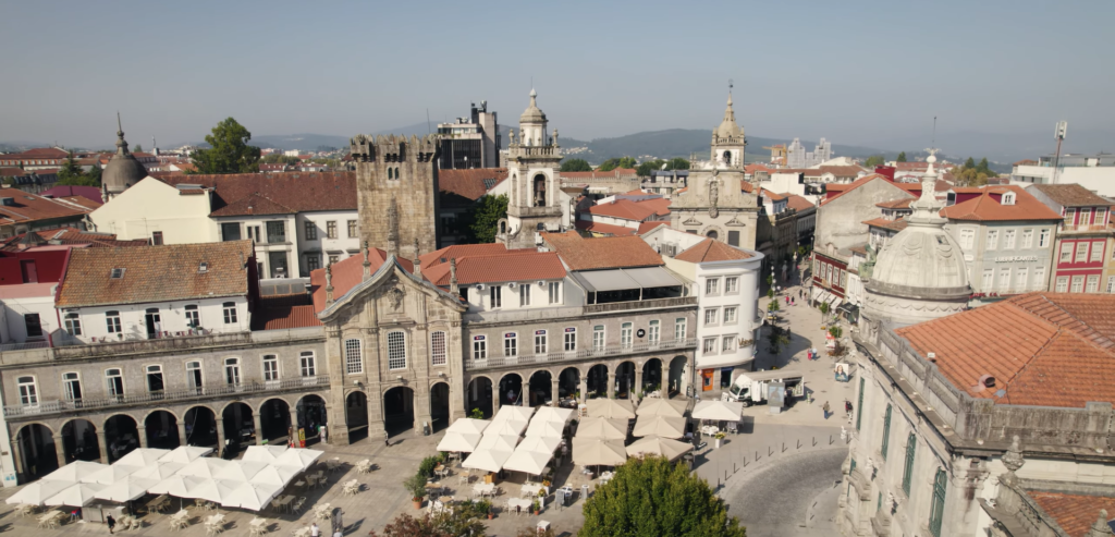 Aerial view of Braga's historic city center, showcasing its dense layout with iconic buildings and bustling streets.