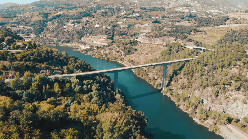 Panoramic view of the Douro Valley, with terraced vineyards cascading down the hillsides to the meandering Douro River.