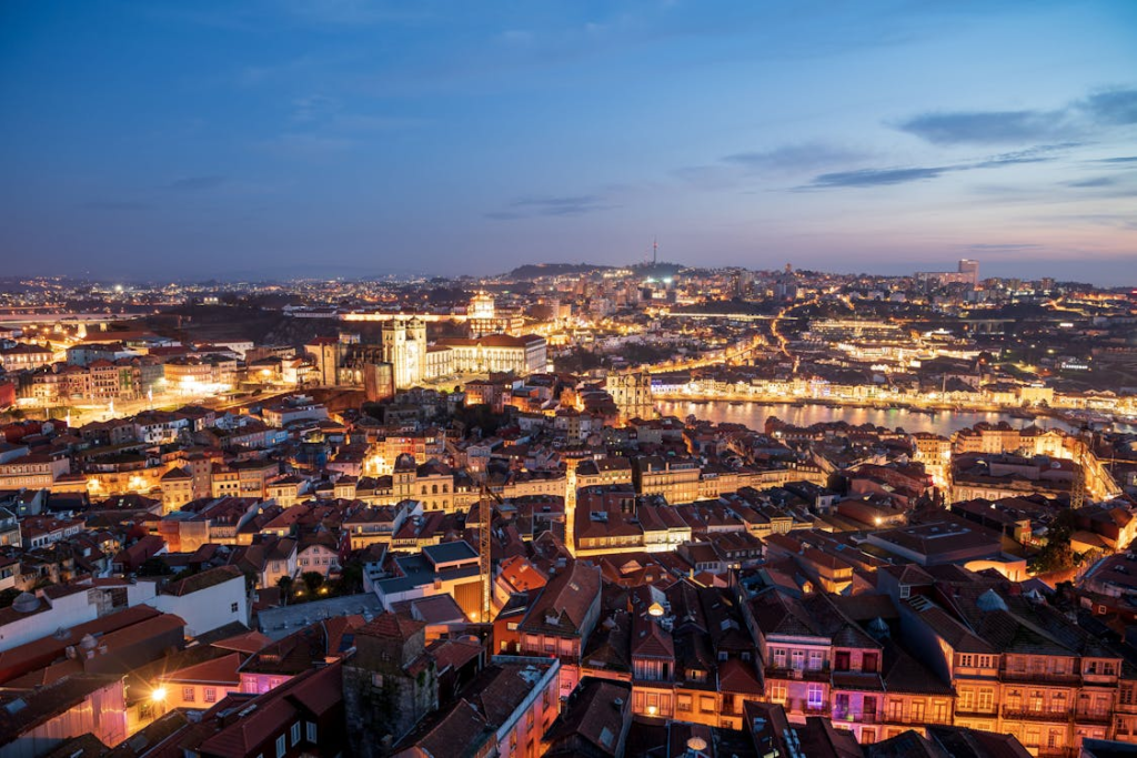 Aerial night view of Porto, lit by countless lights, highlighting the city's lively atmosphere and bustling streets.